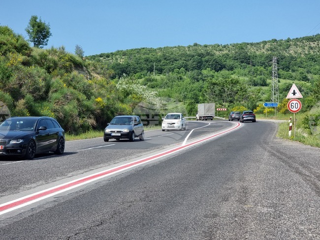 Работници полагат маркировката за гъвкавите ограничители в невралгични участъци от пътя за Маказа в района на Черноочене 