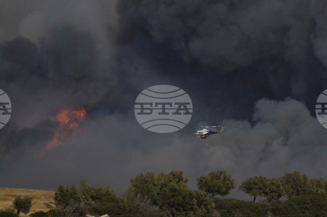 Възрастен мъж е загинал в големия пожар, който продължава да бушува край гръцката столица Атина