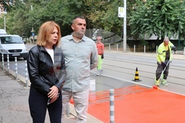 Workers are putting a specialty road dressing designed to slow down cars as they approach a pedestrian crossing in Sofia